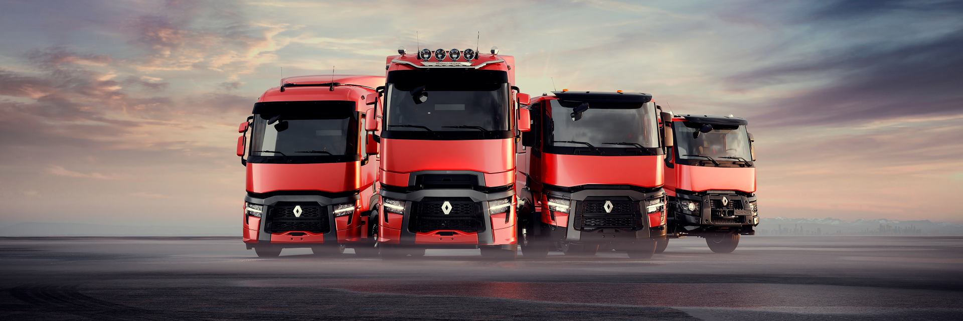 Range of red Renault Trucks lined up an outdoor environment.