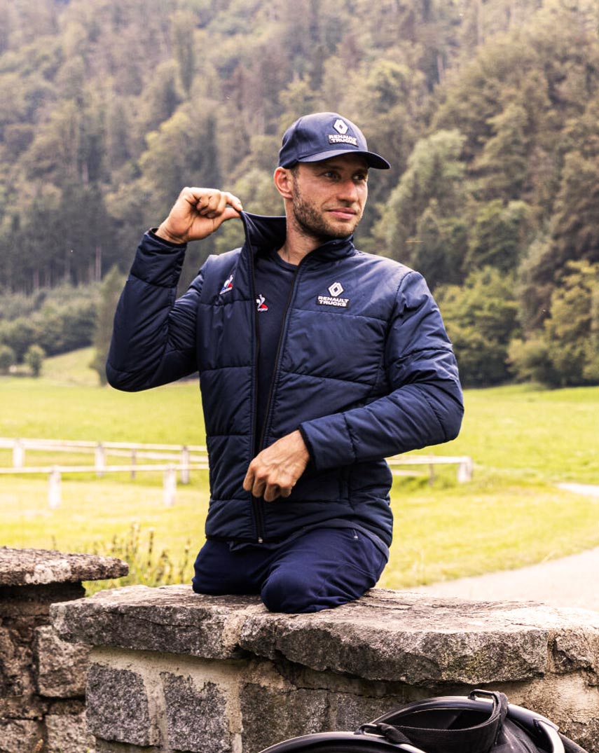 Man in Le Coq Sportif and Renault Trucks blue navy jacket