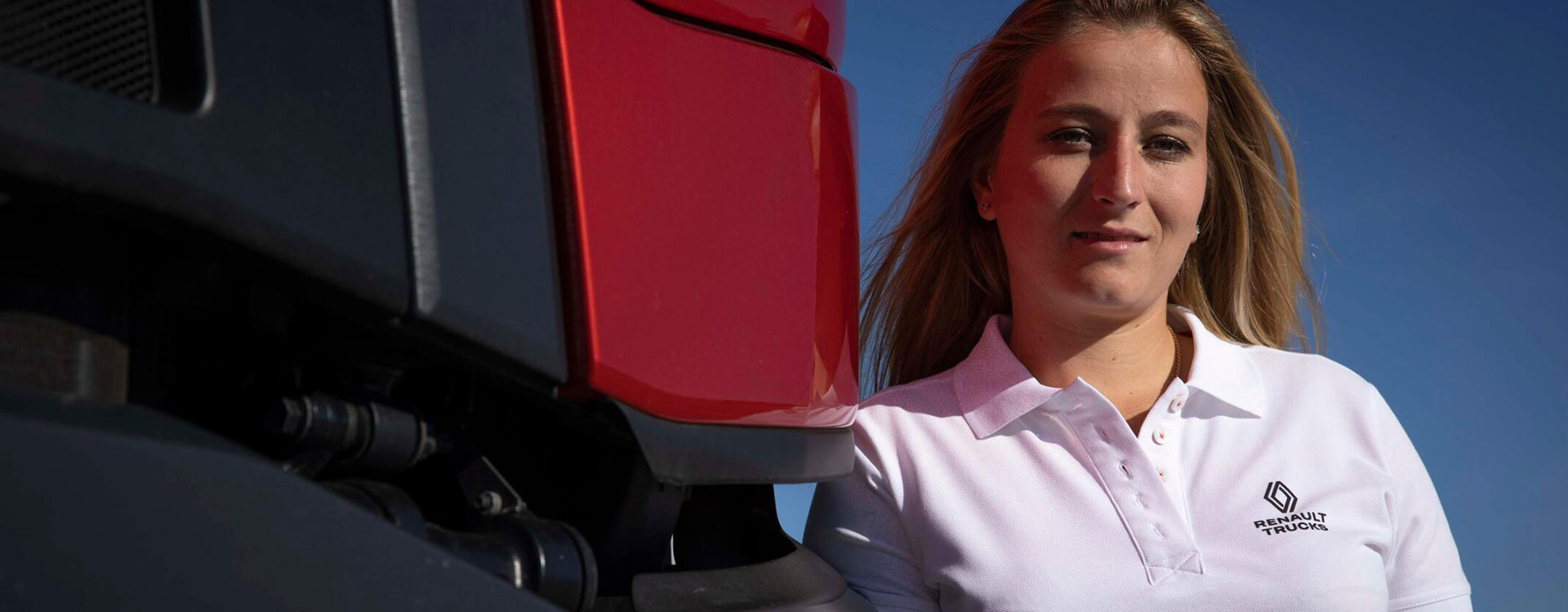 Women wearing Renault Trucks merchandise standing against red truck